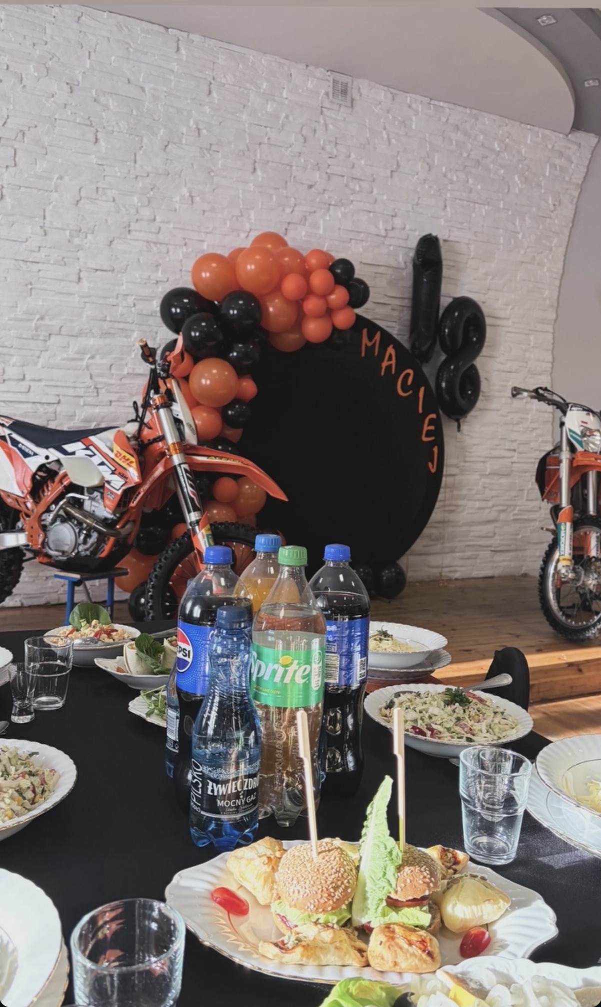 Dekoracje na osiemnaste urodziny z pomarańczowymi balonami i motocyklami